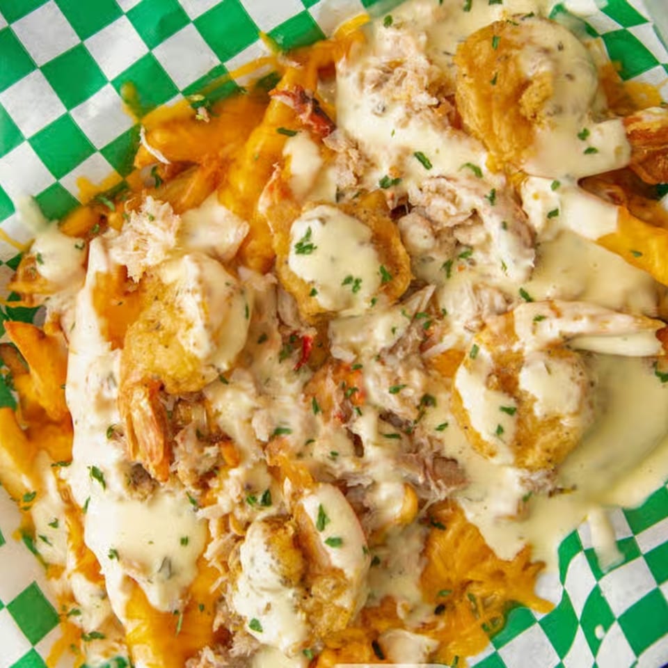 Louisiana Famous Fried Chicken's loaded fries with melted cheese, fried shrimp, and crab meat.