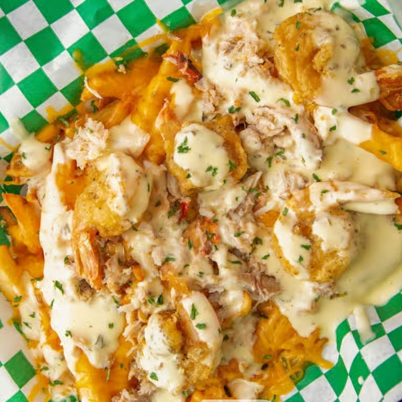 Louisiana Famous Fried Chicken's loaded fries with melted cheese, fried shrimp, and crab meat.